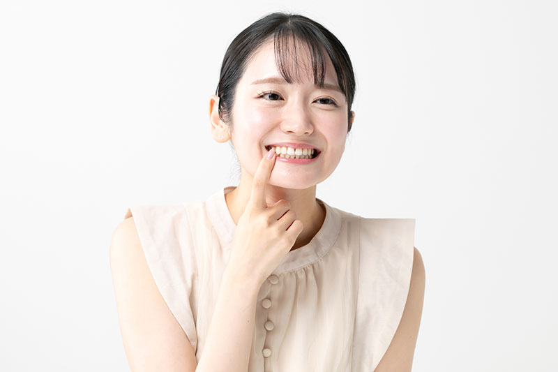 歯を指差す女性